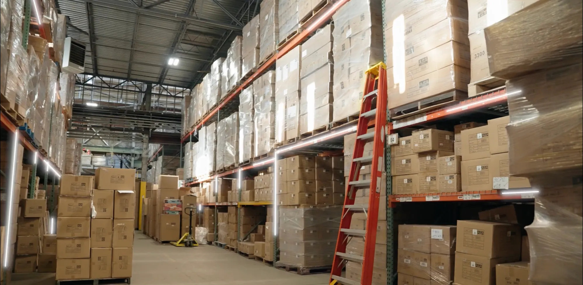 Simulated warehouse aisle with stacked pallets and a ladder, rendered by Claryo's World Model